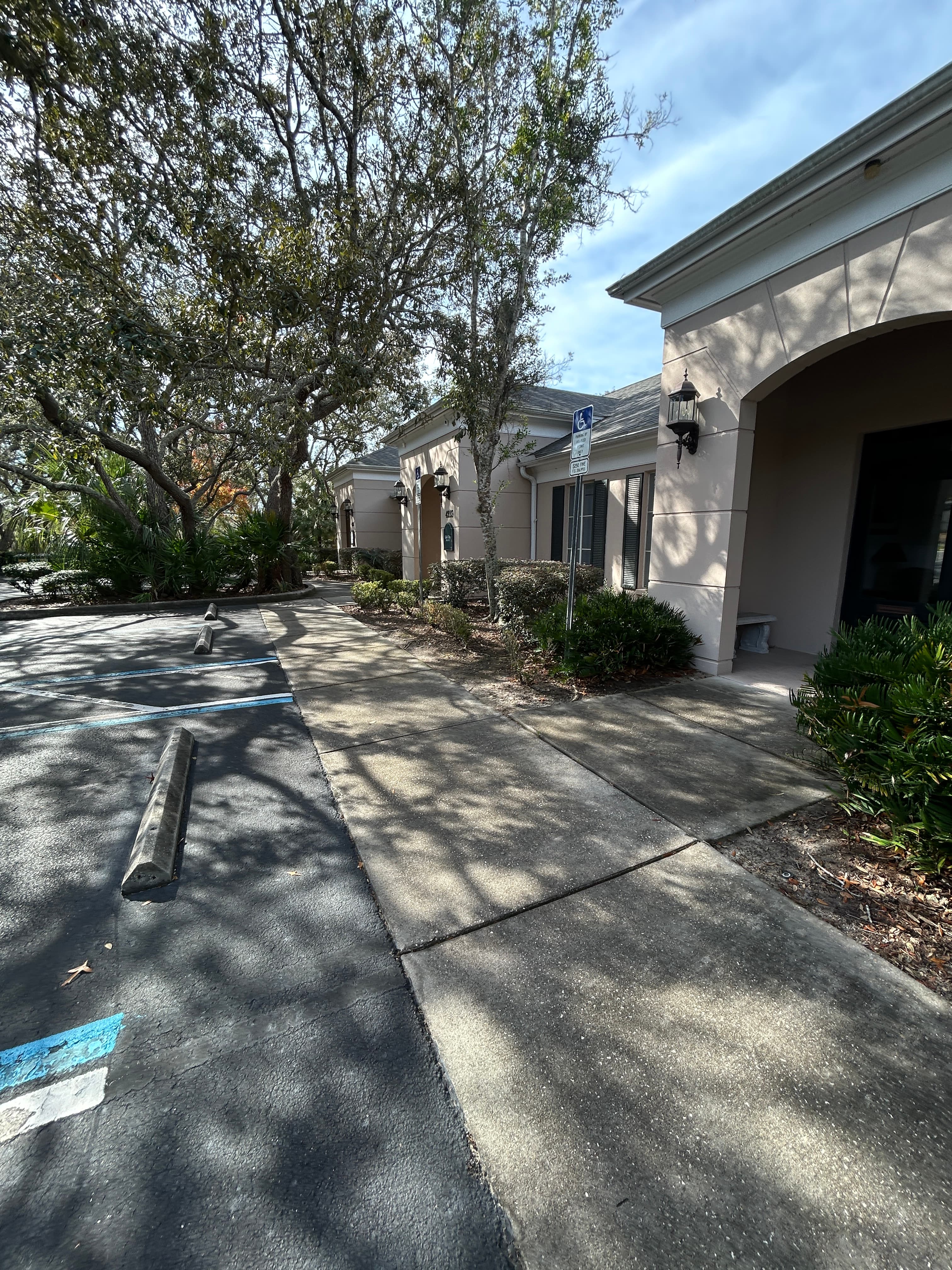 Before: Commercial building walkway and parking area needing pressure washing in Spring Hill FL
